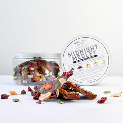 stacked-dark-milk-chocolate-barks-topped-with-trail-mix-beside-container-on-white-background